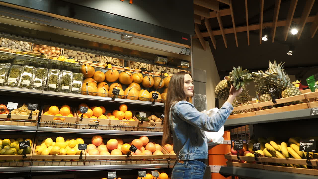 Girl at the shopping center choosing fruits and vegetables hands fresh red apple. Healthy eating. Raw food. Diet.