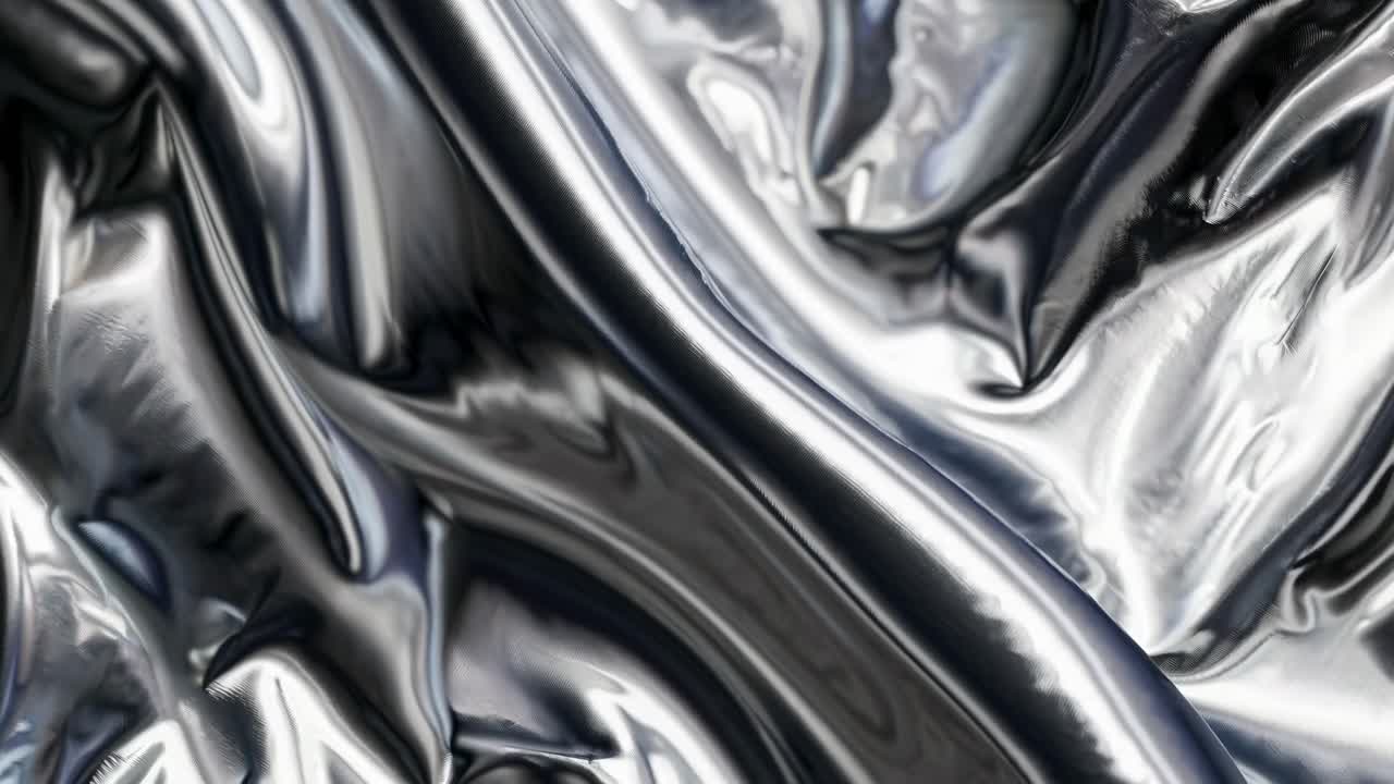 Close-up video of metallic fabric with fluid, reflective surfaces