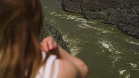 Foamy-water-stream-of-mountain-river-and-woman-on-bank