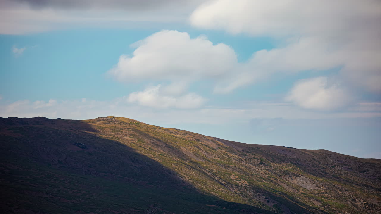 Aikaviivekuvaus tasaisesta tuulen leikkauksesta, joka muodostaa pilvien varjoja vuoren huipulle