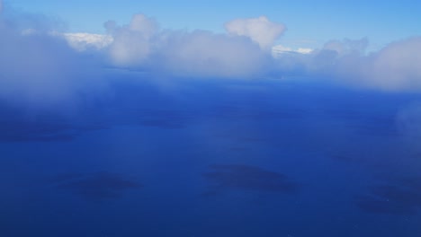 una vista desde un avión captura la impresionante vista de atravesar las nubes sobre el mar, mostrando la belleza de las nubes blancas y esponjosas que contrastan con el azul profundo del océano