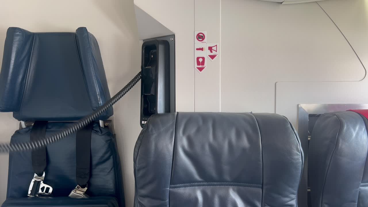 una azafata masculina usando un micrófono de mano en un avión