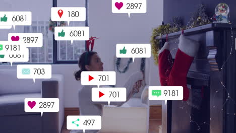 animación de iconos de redes sociales con números sobre mujer caucásica decorando la casa para navidad