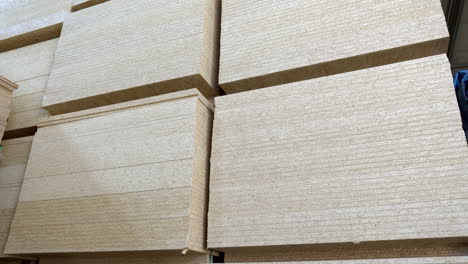 Stack-of-full-size-OSB-chipboard-pallets,-ready-to-pick-up-by-forklift