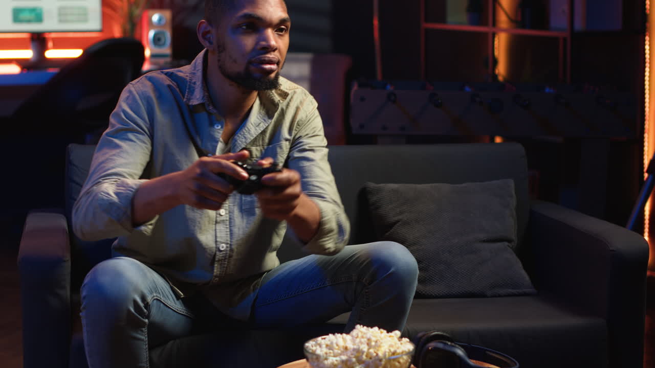 Vertical Video Male gamer eating popcorn while he plays online shooting tournament