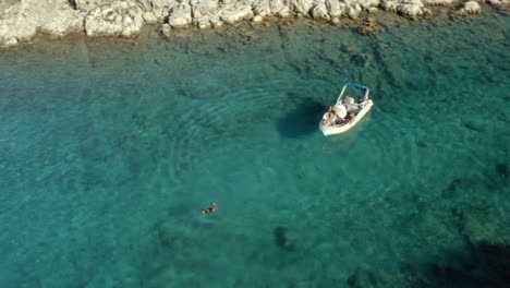 female swimming in tropical lagoon in mediterranean sea in greece, aerial