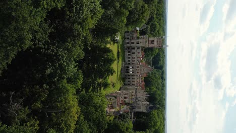 Vertical-shot-of-old-castle-in-the-middle-of-the-forest,-Kopice,-Poland