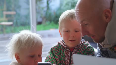 father and children using mobile phone at home 4k