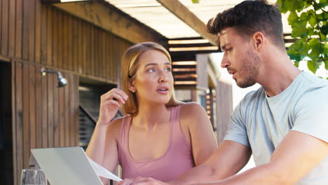 worried couple using laptop at home to check domestic finances