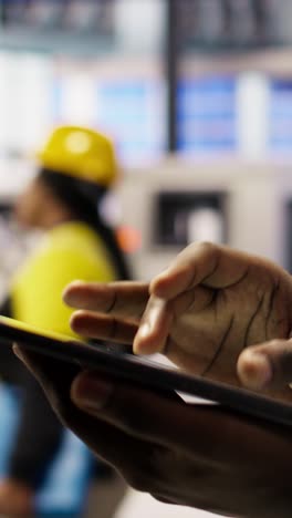 vertical video close up of tablet used by smart factory specialist