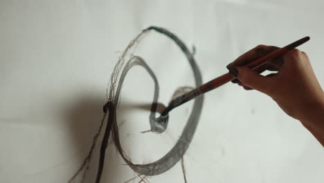 mujer desconocida creando una imagen en el taller. pintor pintando a mano en el estudio.