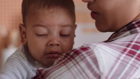 unhappy baby crying on mothers shoulder upset infant screaming with young mom calming tired child