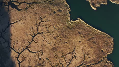 4k,-El-Dron-Vuela-Sobre-El-Lago-Azul-Con-Hierba-Seca-Que-Cubre-La-Mayor-Parte-De-La-Superficie,-Dejando-El-Lago-En-Forma-De-Sendero