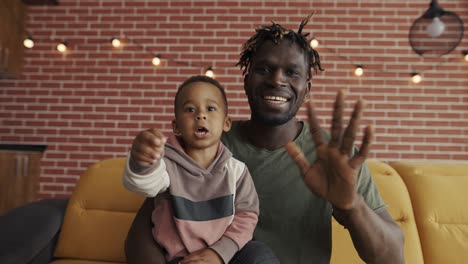 Portrait-African-American-father-and-preschooler-child-speak-on-conversation-video-chat-from-home