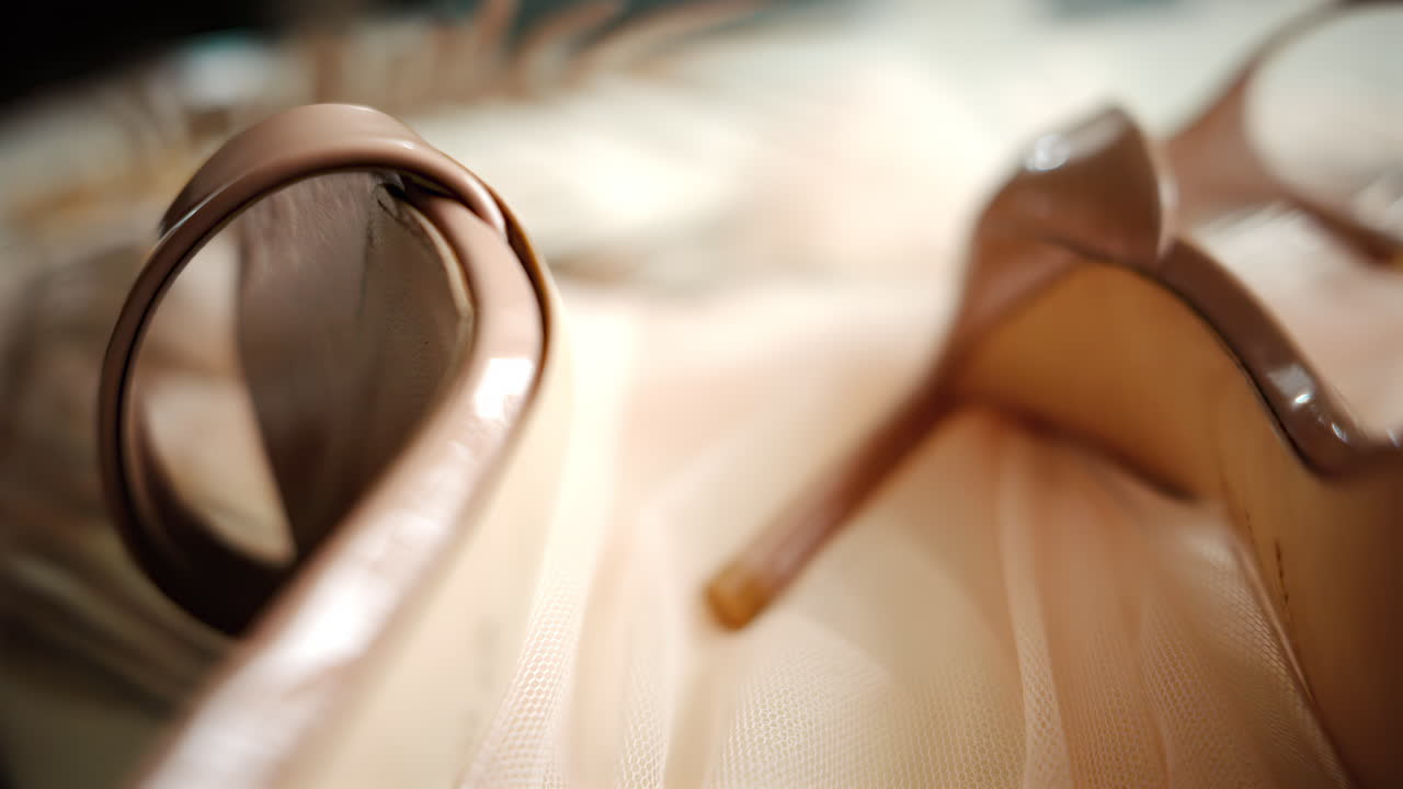 A beige pair of strappy heels on a piece of tulle
