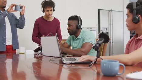 happy diverse male friends talking and recording in living room