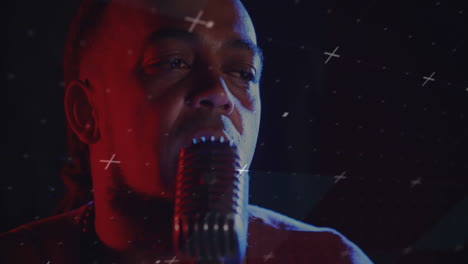 male singer leaning into retro mic under stage lights, displaying animated white crosses for music