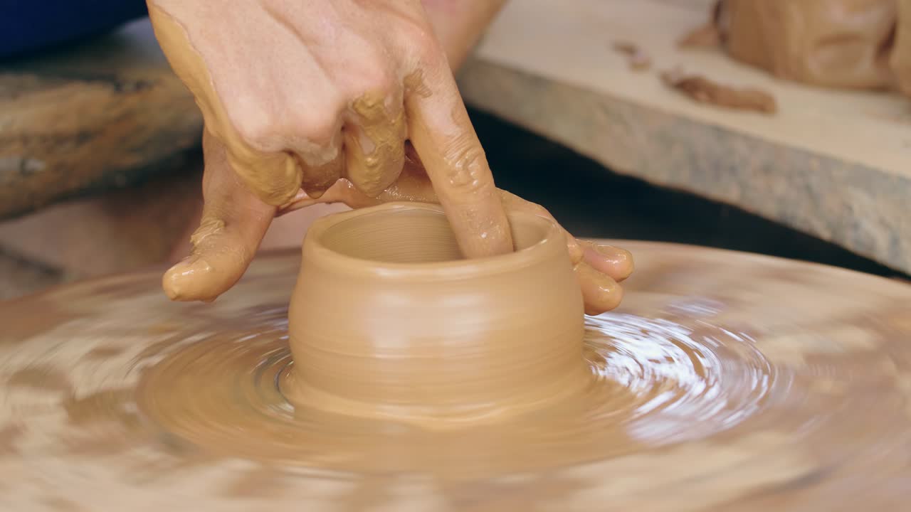 Person Shaping a Bowl on a Pottery Wheel