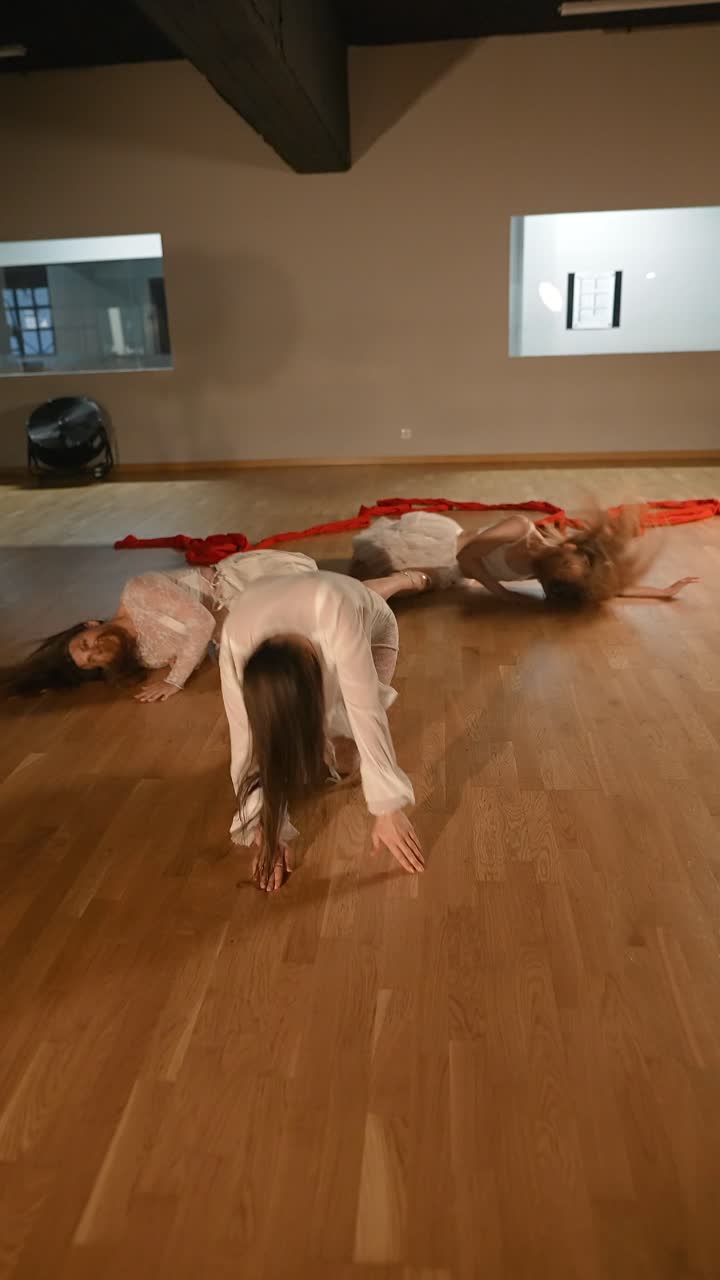 Contemporary Dance Performance with White Clothing and Red Ribbons