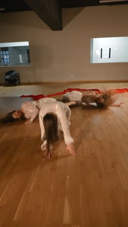 contemporary dance performance with white clothing and red ribbons