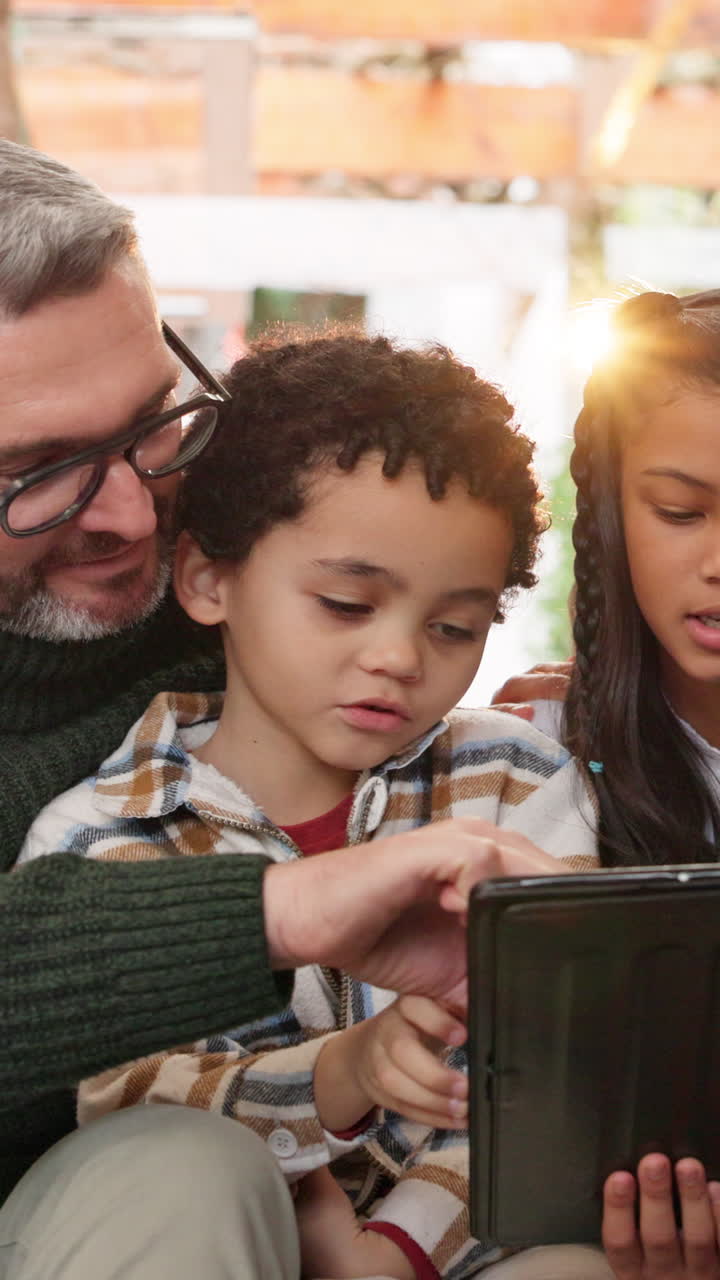 Una famiglia multietnica crea legami mentre impara usando un tablet digitale a casa