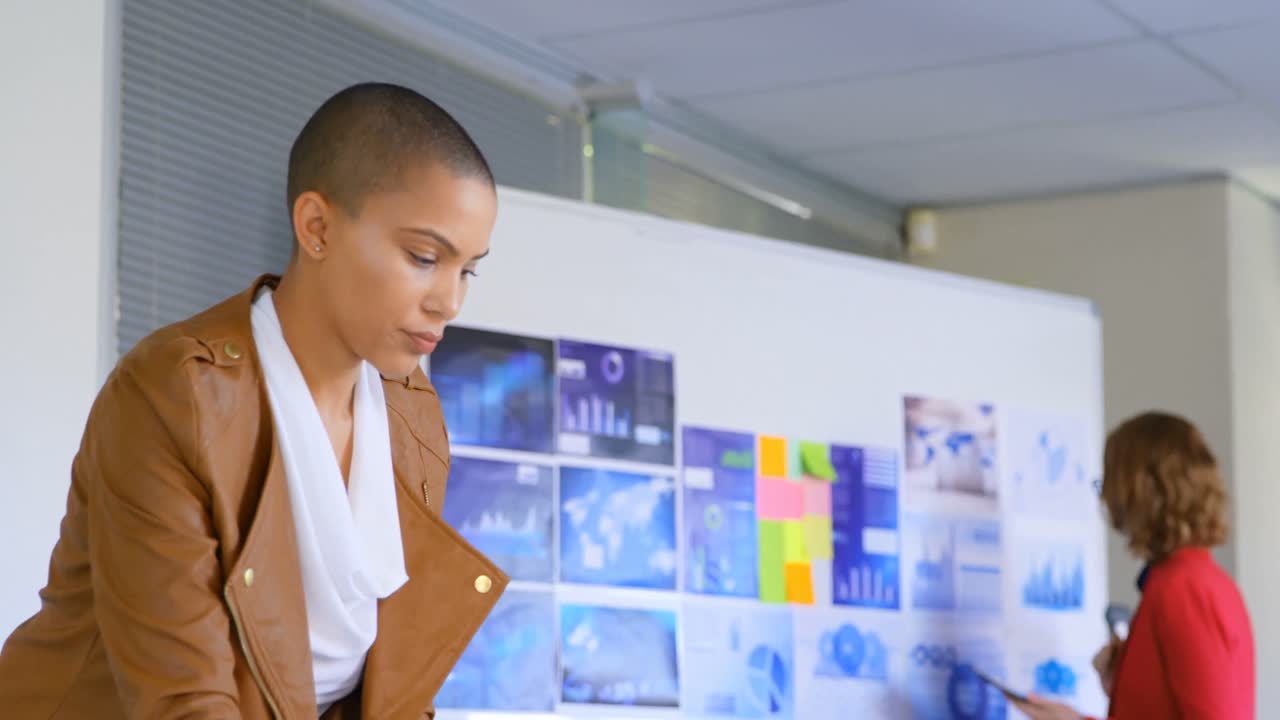 vista lateral de una joven ejecutiva caucásica trabajando en una computadora portátil en una oficina moderna 4k