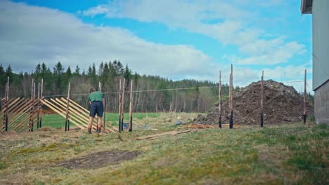 caucasian man making a skigard wooden fence. timelapse