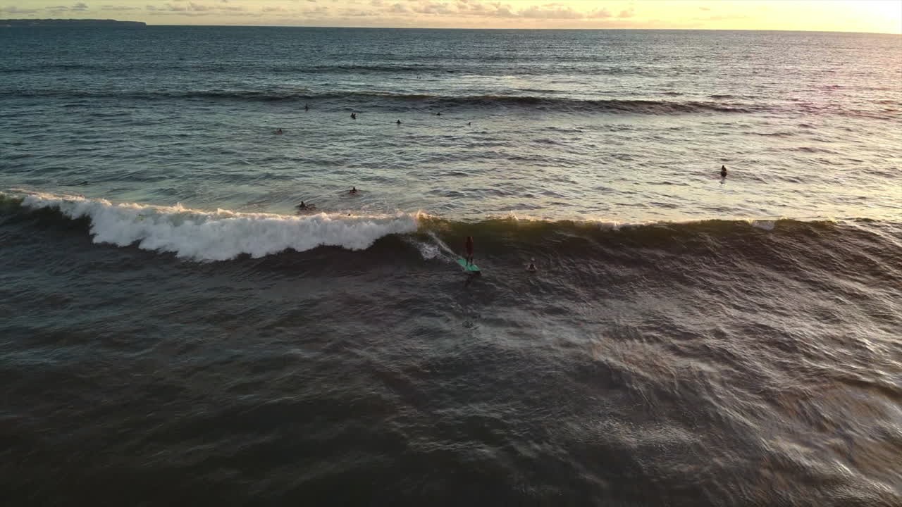surfistas atrapando olas al atardecer