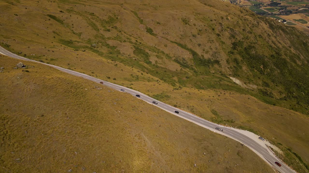vista aérea de los automóviles que conducen a lo largo del paso de montaña cardrona en la cordillera de la corona, otago