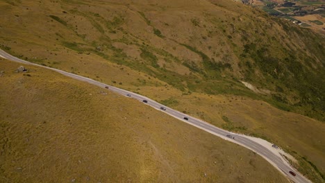 Aerial-view-of-cars-driving-along-Cardrona-mountain-pass-in-Crown-Range,-Otago