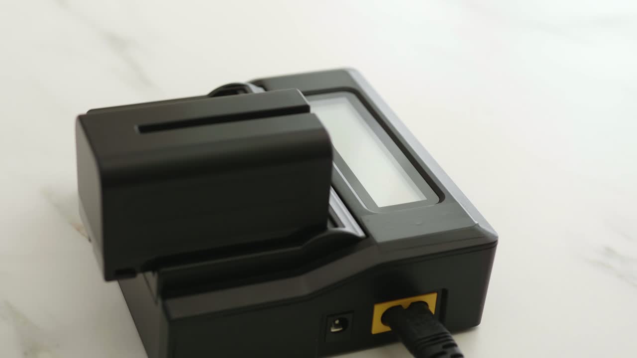 cerrar la mano del hombre instalando la batería en el cargador negro con pantalla led