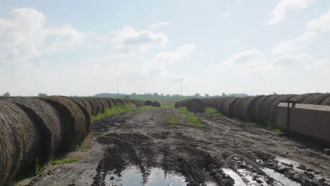 Hay-Bails-Scattered-Across-Muddy-Agricultural-Farm-Field