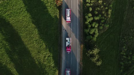 bird eye view of fire trucks convoy in stunning green scenery at sunset 4k