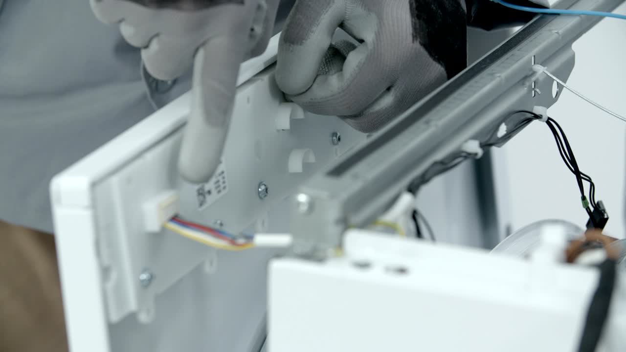 reparador quitando el panel lateral delantero de la lavadora