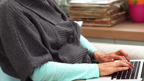 mujer usando una computadora portátil mientras está sentada