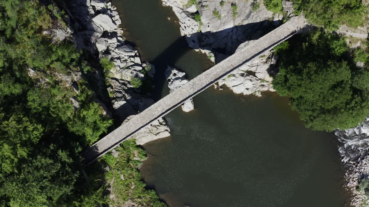 An overhead orbiting drone shot of the full length of Devil's Bridge located in Ardino at the foot of Rhodope Mountain in Bulgaria