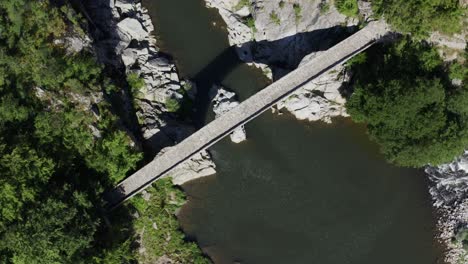 An-overhead-orbiting-drone-shot-of-the-full-length-of-Devil's-Bridge-located-in-Ardino-at-the-foot-of-Rhodope-Mountain-in-Bulgaria