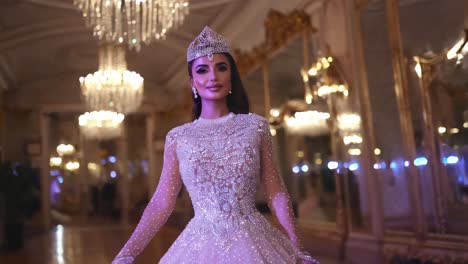 una mujer con un hermoso vestido de cuentas, con una tiara de joyas, en un gran salón