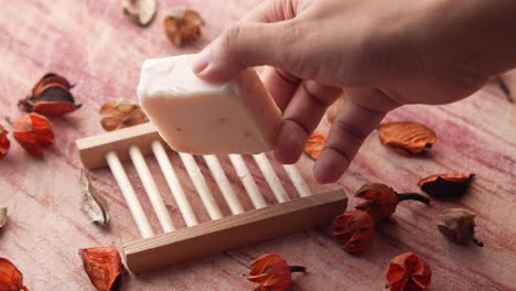 white bar soap in wooden soap dish with dried flowers