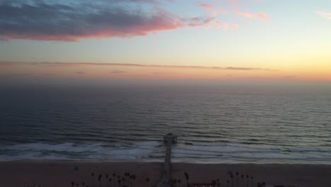 aerial view of the manhattan beach pier and waves breaking on the shore - drone shot