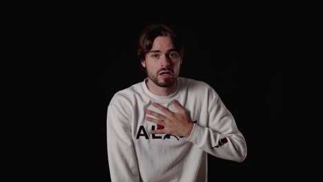 trendy young man frightened gesture, scared expression, wide, black background