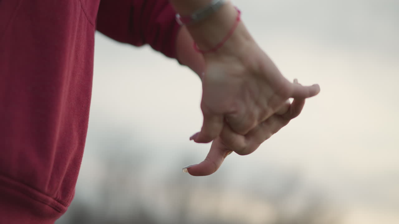 CloseUp Office Worker Hands Relieving Wrist Tension Outdoors. Gentle Palm Rotations And Finger Stretches, Visible Smartwatch And Bracelets, Muted Sky, Calm Breathing And Selfcare Routine