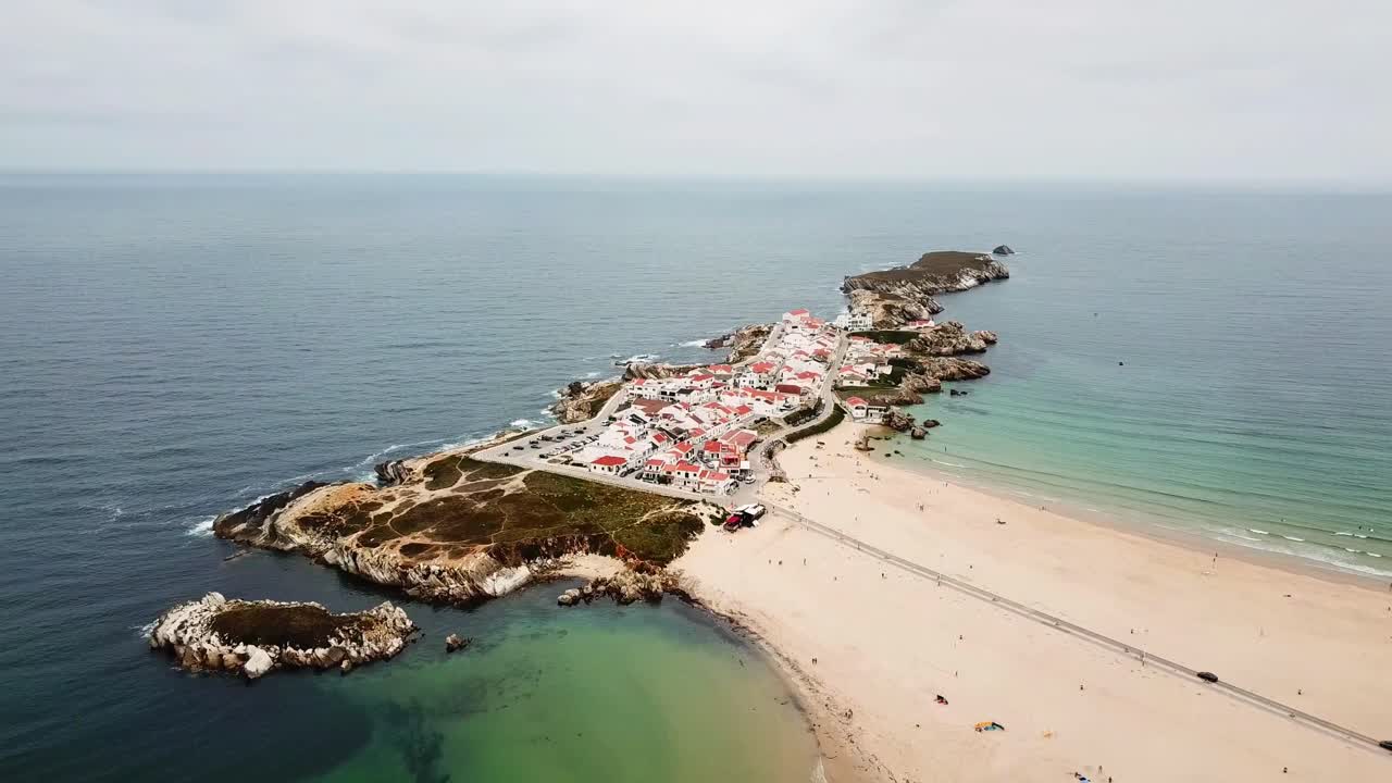 Aerial view of Baleal island and praia Norte, a popular tourist destination known for its beautiful beaches, crystal-clear waters, and charming village in Peniche, Portugal, drone pulling out