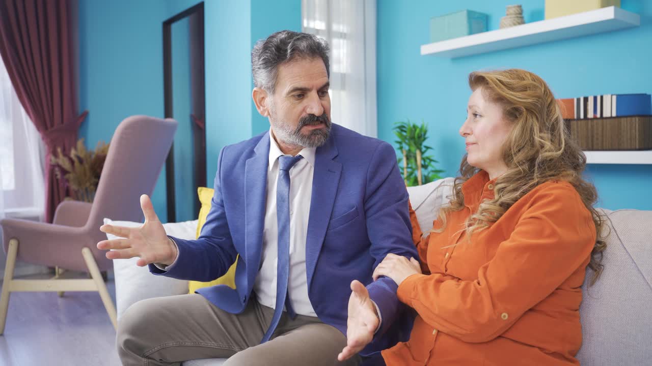 su esposa consuela al hombre enojado cuyo negocio ha ido mal.