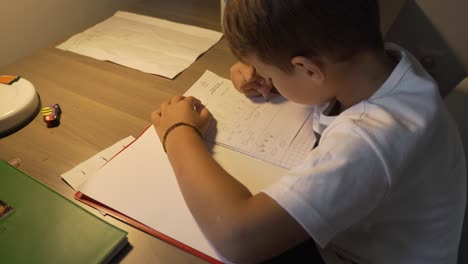 imágenes de un niño caucásico de seis años, haciendo sus lecciones de tarea en casa 4k, vista lateral, plano medio