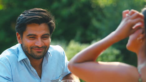 Couple-Outdoors-Drinking-Wine-In-Summer-Garden-At-Home-Together