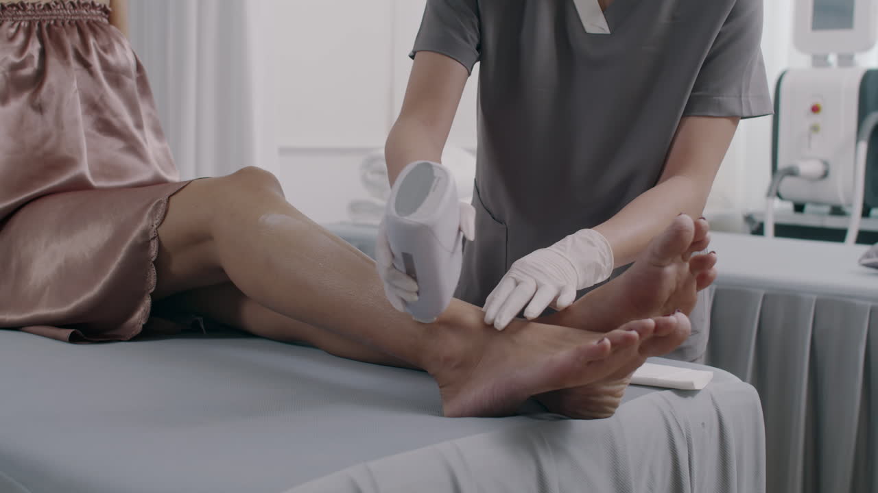 Specialist Using Wax Strips on Clients Legs during Depilation Procedure