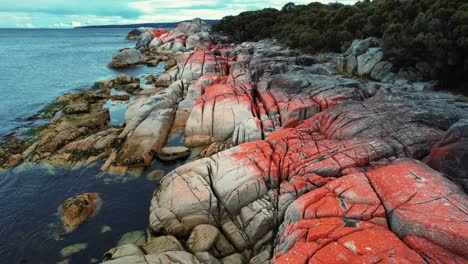 drone de la bahía de incendios del paisaje de roca naranja tasmania, australia