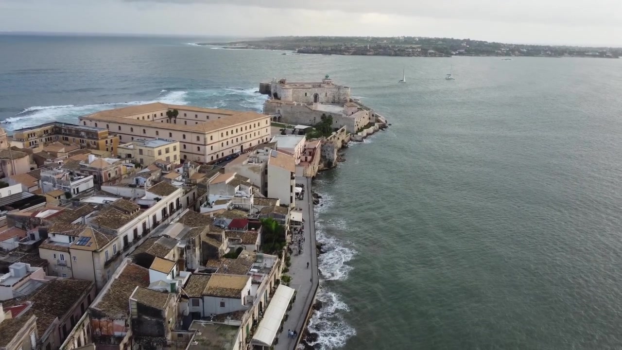 Vue aérienne d'une promenade côtière menant à un château sicilien à la pointe de l'île d'Ortigia