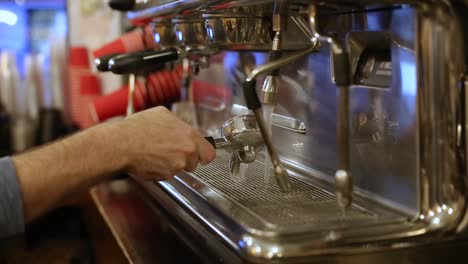 primer plano de un empleado limpiando una máquina de espresso